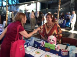 Dr. Erica Shaking Hands at Her Booth